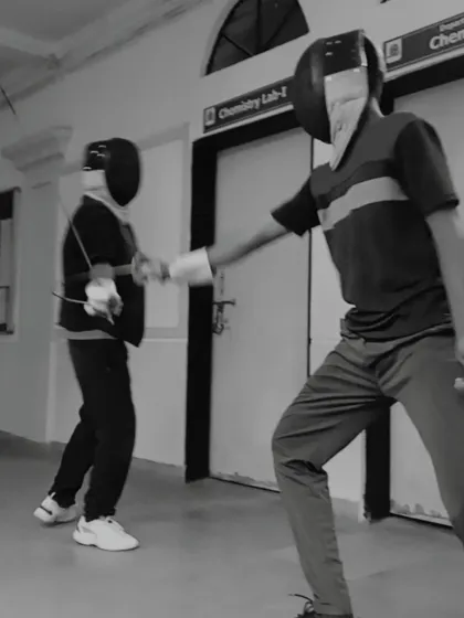 A black and white shot capturing the intensity of a close-quarters exchange between two fencers. This highlights the fast paced nature of the sport.