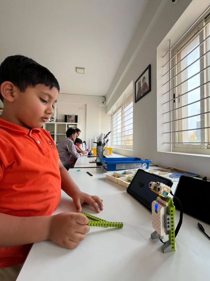 The first day of summer camp is always full of excitement. Here, a student gets hands-on with a LEGO Spike Prime kit, beginning his journey into the world of robotics and programming.