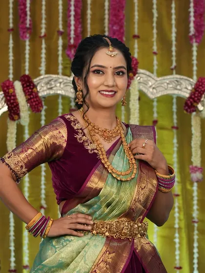 Harshitha looking beautiful for her son's naming ceremony. Her sea-green and maroon saree is paired with soft, pretty makeup.
