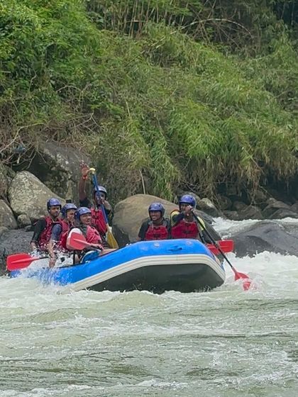 A raft team carefully maneuvers through a rocky section of the river in Coorg. Our guides teach essential skills for navigating different types of water conditions.