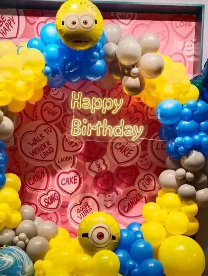 A Minions-themed photo booth area with a fun, colorful backdrop and Minion character balloon sculptures.