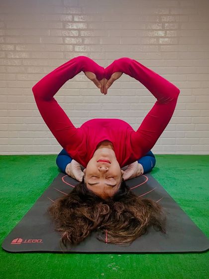 Matsyasana, or Fish Pose, with hands forming a heart shape. This supported backbend opens the heart chakra and is a beautiful expression of self-love and kindness.