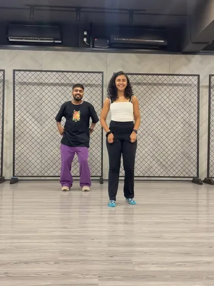 Posing with a dance partner in the studio. The industrial-style background with mesh panels is a space where so much creativity happens.