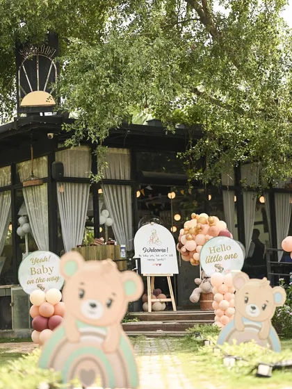 The welcoming entrance to a boho-chic baby shower at The Sunroom. The path is lined with cute bear cutouts and signs like 'Hello little one', creating a warm and inviting entryway.