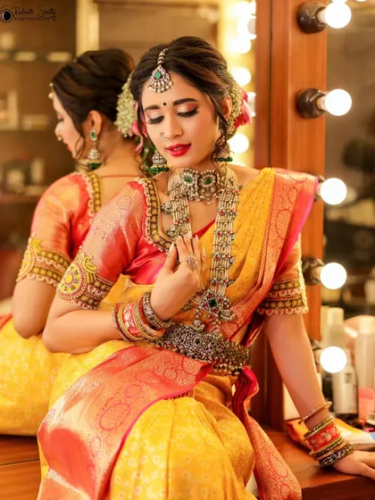 A quiet moment of reflection before a traditional bridal shoot. Using the mirror adds depth to the portrait, capturing both the model's elegant profile and the intricate details of her jewelry and saree.