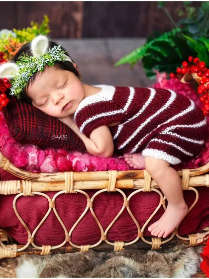 So tiny and perfect in a striped red and white outfit with little fawn ears. Themed outfits add a touch of whimsy and fun to any newborn session.