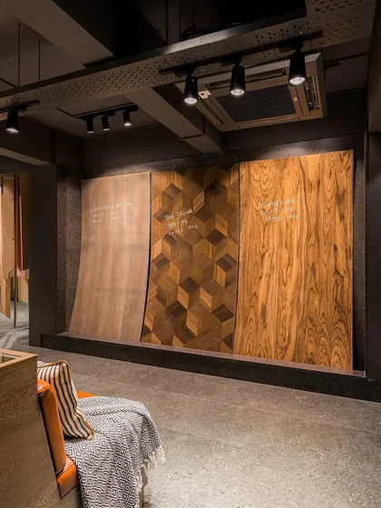 A wall dedicated to showcasing large-format veneer sheets, allowing clients to appreciate the full pattern and grain of the wood.