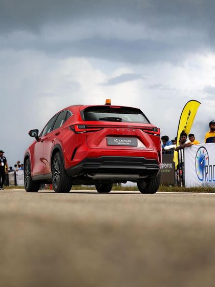 A red Lexus NX, our safety car, on the track. Even our official vehicles are stylish and performance-oriented, reflecting the premium nature of the event.