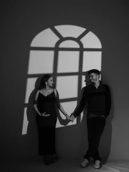 A black and white portrait of the couple holding hands, framed by the window shadow. This composition tells a story of partnership and looking towards a shared future together.