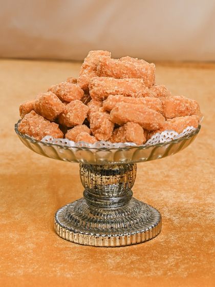 These are my delicate Gur Pare, a traditional sweet and crunchy snack made with jaggery. They are a nostalgic treat that I love including in my wedding savouries collection.