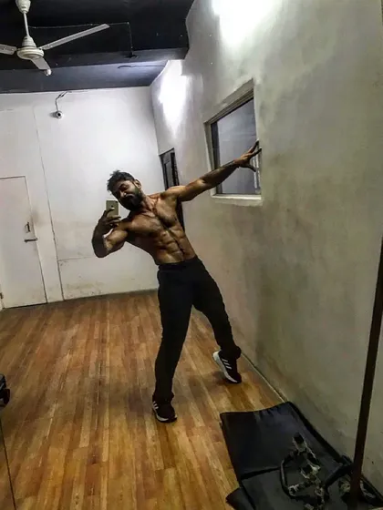 Another angle of the classic physique pose, showcasing a lean midsection.