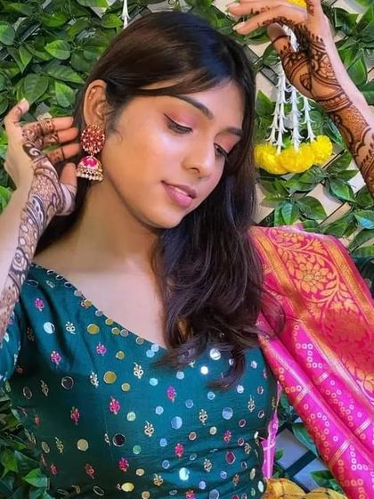 A beautiful client posing elegantly, showcasing her detailed arm mehndi.