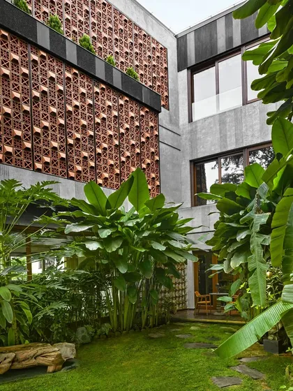 The garden courtyard at Project 58 is a tranquil oasis, with the building's facade of terracotta and textured concrete providing a rich backdrop.