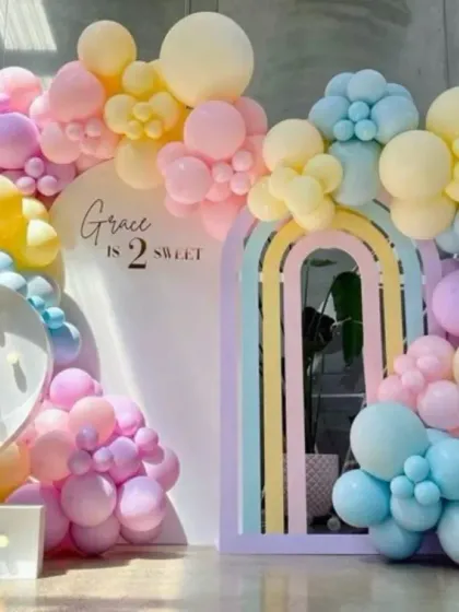 A "Grace is 2 Sweet" pastel rainbow birthday theme. This beautiful setup uses a variety of pastel-colored balloons to create a soft and dreamy atmosphere, complete with a large light-up number '2'.