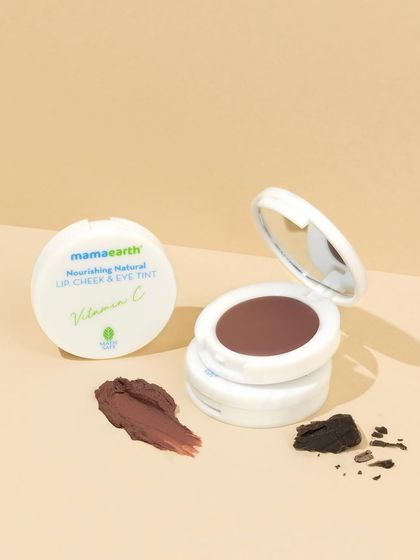 This shot focuses on a single shade of lip tint, styled with a rich texture swatch and pieces of chocolate to hint at its color and scent. The minimal styling keeps the focus entirely on the product.