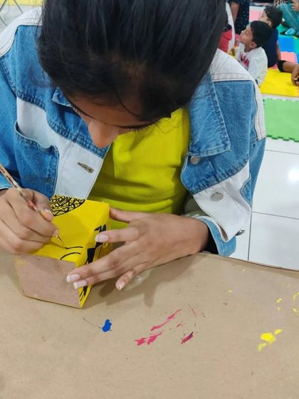 A young artist painting a project during a group art session. We hosted kids and moms who came all the way from Tumkur!