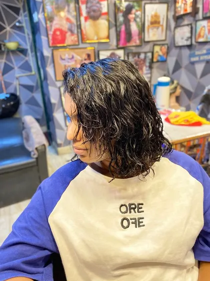 A side view of the newly permed hair. These wet curls will take on a softer, more voluminous look once they are fully dry and styled.