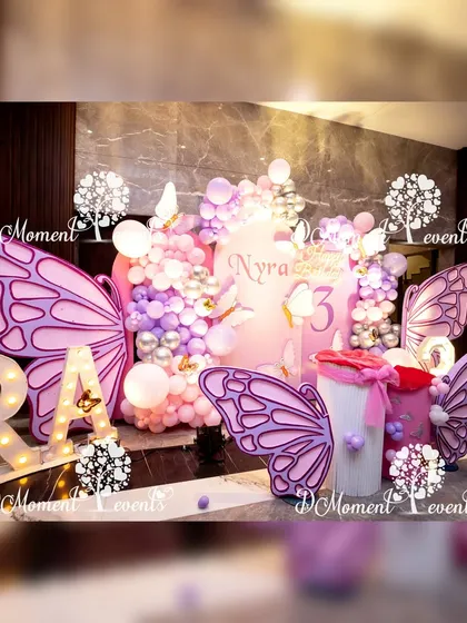 A close-up of the butterfly-themed stage, showing the detailed balloon work and the layering of the butterfly wing props to create a sense of depth.