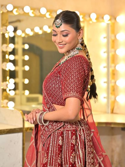 A complete bridal look featuring a heavy, gold-plated Kundan necklace, haath phool, and maang tikka, all available for rent.