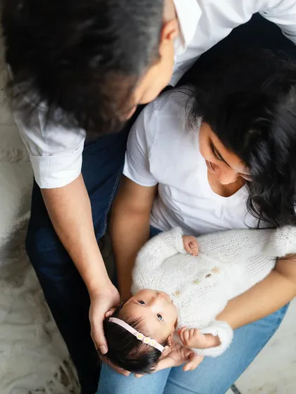 An overhead perspective of the family admiring their baby. This angle provides a unique and intimate view of their loving interaction.