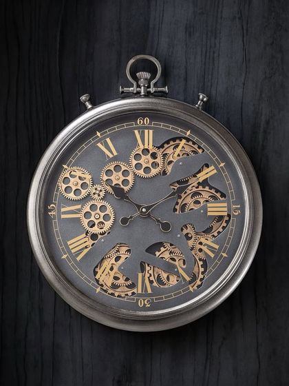 This pocket-watch style wall clock features a distressed silver finish and exposed moving gears. Its timeless design and sturdy body make it a perfect fit for both modern and traditional interiors.
