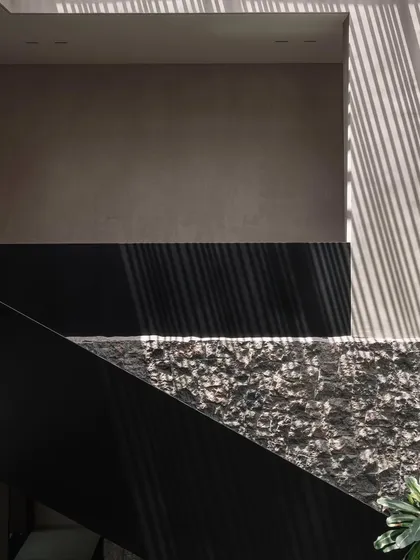 A close-up of the textured stone wall and the sharp, modern lines of the black metal railing, showcasing the contrast of materials we used in this project.
