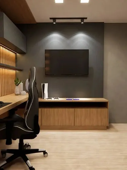 A modern gaming room with a dark and moody color palette. The design includes a large desk, a comfortable gaming chair, and a wall-mounted TV.