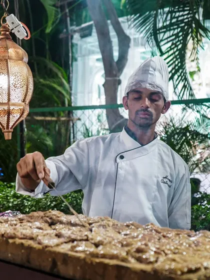 A chef at our live tawa counter, preparing one of our signature dishes. This interactive station is always a hit with guests.