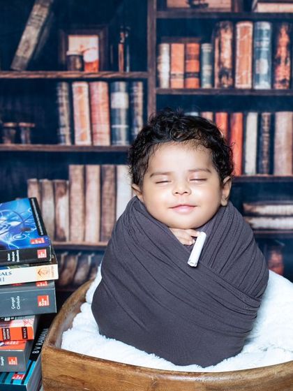 This little scholar is dreaming of physics and engineering, surrounded by a stack of advanced textbooks.