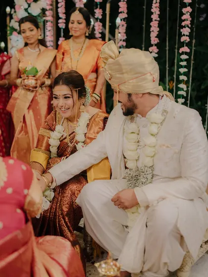 A candid moment of interaction during the wedding ceremony. The groom's gentle gesture and the bride's smile show their easy rapport.