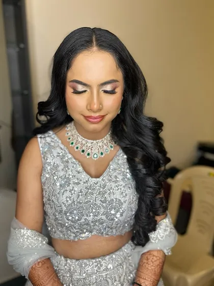 A beautiful portrait of this bride in her silver lehenga, her makeup glamorous and her hair in soft, voluminous curls.