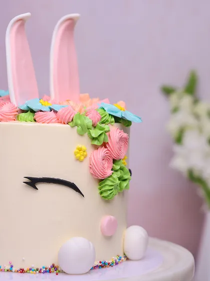 A side view of the Easter bunny cake, showing the detail in the piped flowers and the cute fondant ears.