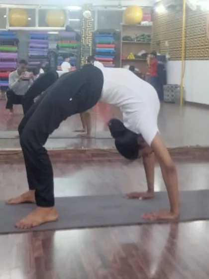 A student holding a strong Urdhva Dhanurasana, or wheel pose. This powerful backbend energizes the whole body.