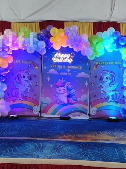 A magical unicorn-themed birthday party with multiple backdrops and cute unicorn character cutouts.