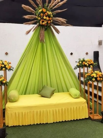 A simple and elegant seating for a Dholki or Mehndi function, using lime green drapes and marigold accents for a fresh look.