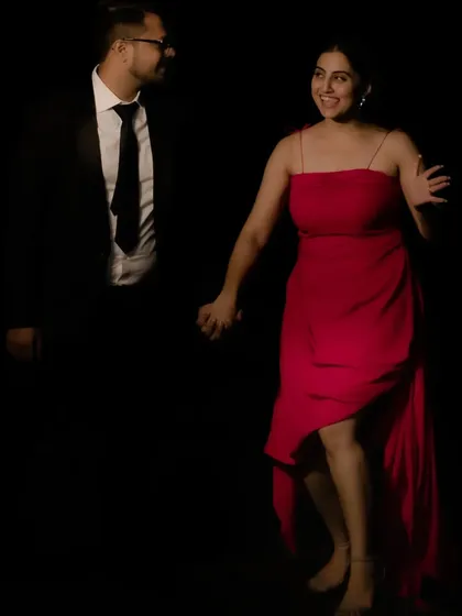 I designed this vibrant red cocktail dress for a client's pre-wedding festivities. The dress features a modern, asymmetrical high-low hemline and delicate spaghetti straps. The dark, moody lighting of the shoot makes the red color pop.