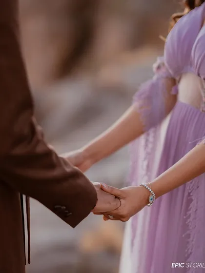 A close-up on the hands. Sometimes the smallest details tell the biggest story. This shot of the couple holding hands, with the beautiful landscape in the background, symbolizes their connection and shared journey.
