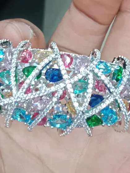 A vibrant and colourful bracelet featuring multi-coloured stones set in a criss-cross American Diamond pattern. This is a fun and festive piece that can brighten up any outfit.