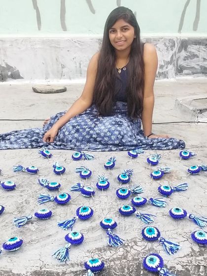 Me with my creations! Spreading out a large order of evil eye keychains to do a final quality check before packing.