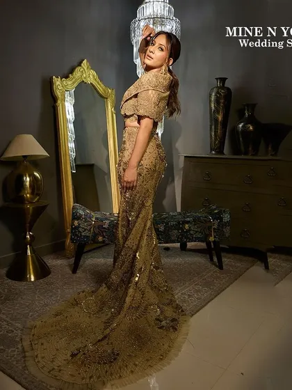 A high-fashion moment from the Mine N Yours Wedding Show. We created a dramatic and glamorous look with a sleek updo and striking makeup to match the golden, floor-length gown.