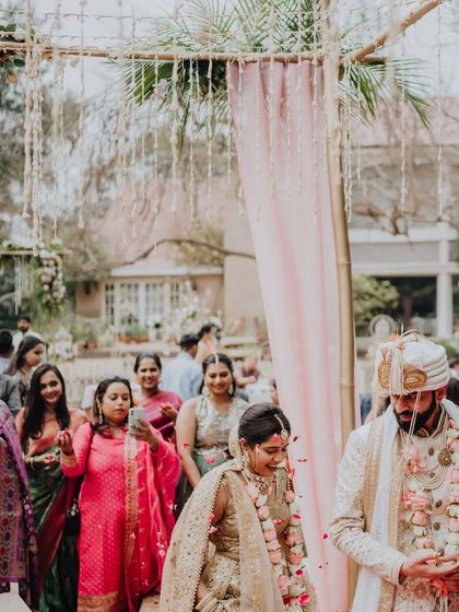 The couple's grand entrance to their garden wedding, showered with petals by their loved ones.