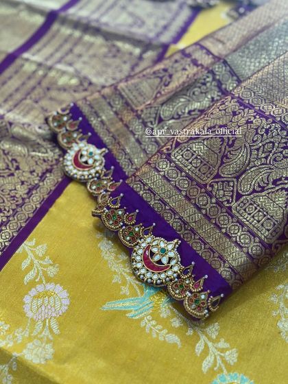 A close-up of the intricate cuff detail on the purple blouse.