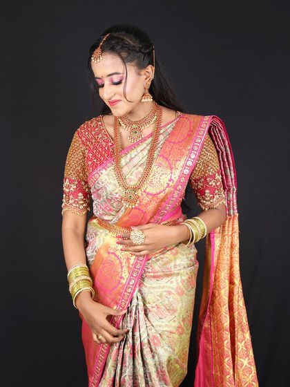 A stunning South Indian engagement look. The makeup features a beautiful pink eyeshadow to match her saree and glowing, radiant skin.