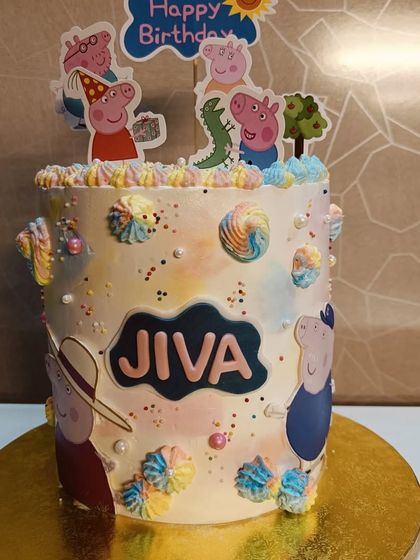 A playful Peppa Pig themed cake. The design uses a watercolor buttercream effect and features characters from the popular show.