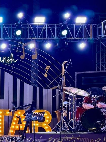 A close-up of the stage details, including a real saxophone, drum kit, and music stand, adding authenticity to the rockstar theme.