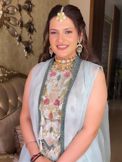 A beautiful Mehendi look with a soft, pastel outfit. The makeup is kept fresh and glowing, with a pop of shimmer on the eyes.