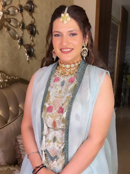 A beautiful Mehendi look with a soft, pastel outfit. The makeup is kept fresh and glowing, with a pop of shimmer on the eyes.