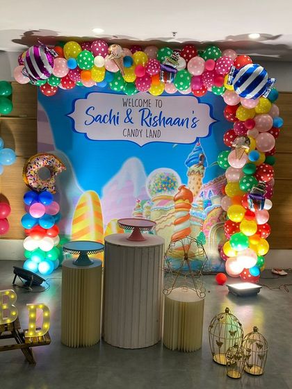 Welcome to Candyland! This sweet theme features a custom backdrop of a candy world and a balloon arch decorated with donut and ice cream foil balloons.