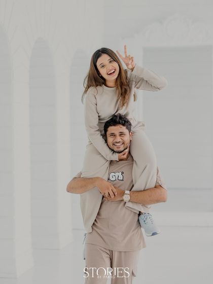 A happy peace sign from atop his shoulders. This shot is all about capturing the carefree, joyful spirit of the couple during their fun and casual pre-wedding session.