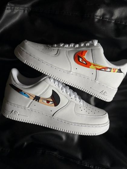 A pair shot of the Naruto and Sasuke custom sneakers, with each character's eye design in the swoosh.